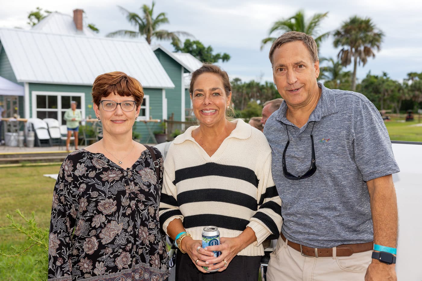 three people smiling standing outdoors watch party 2023