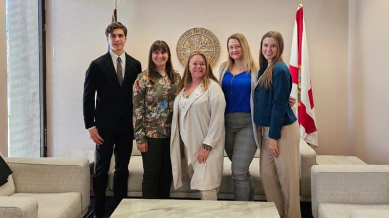 five people stand indoors in Florida state capitol