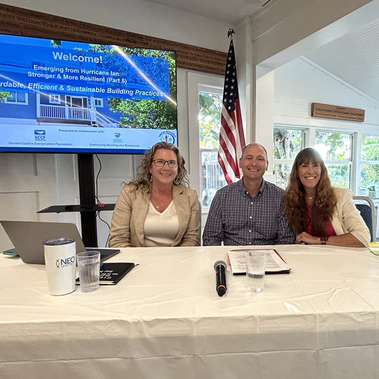 Three people sitting at table and smiling