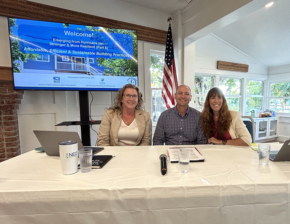Three people sitting at table and smiling