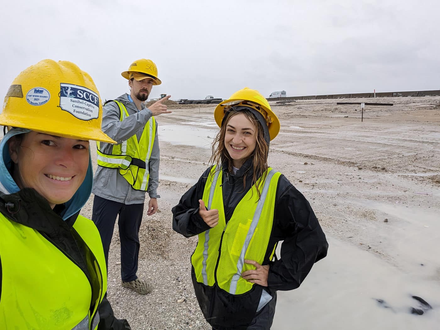 three people stand in rain