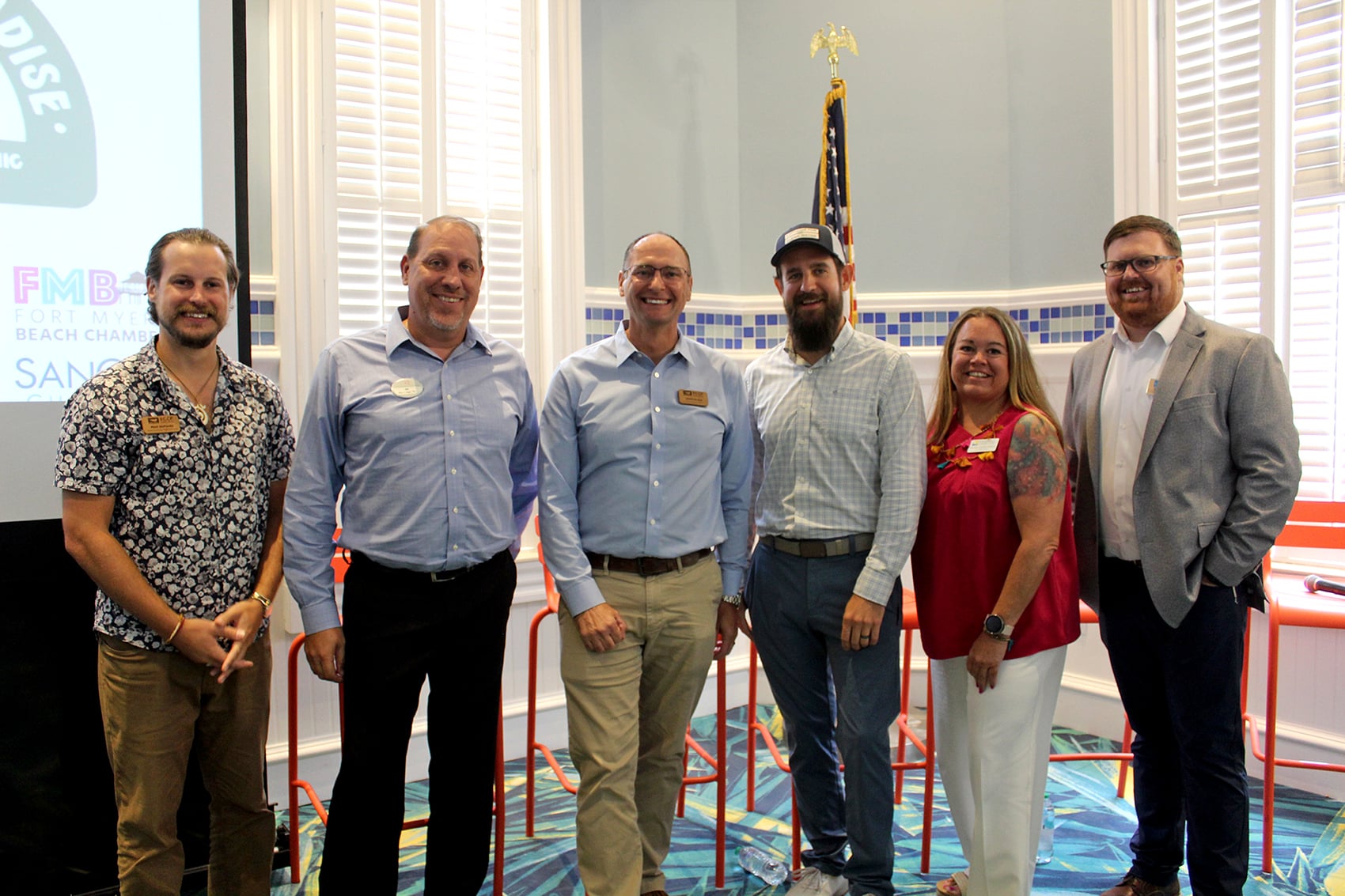 group of six people standing and smiling indoors