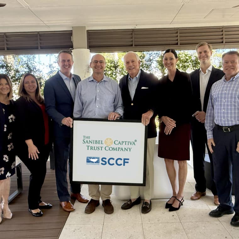 group of people in business clothes holding sign that says 'sancap trust sccf'