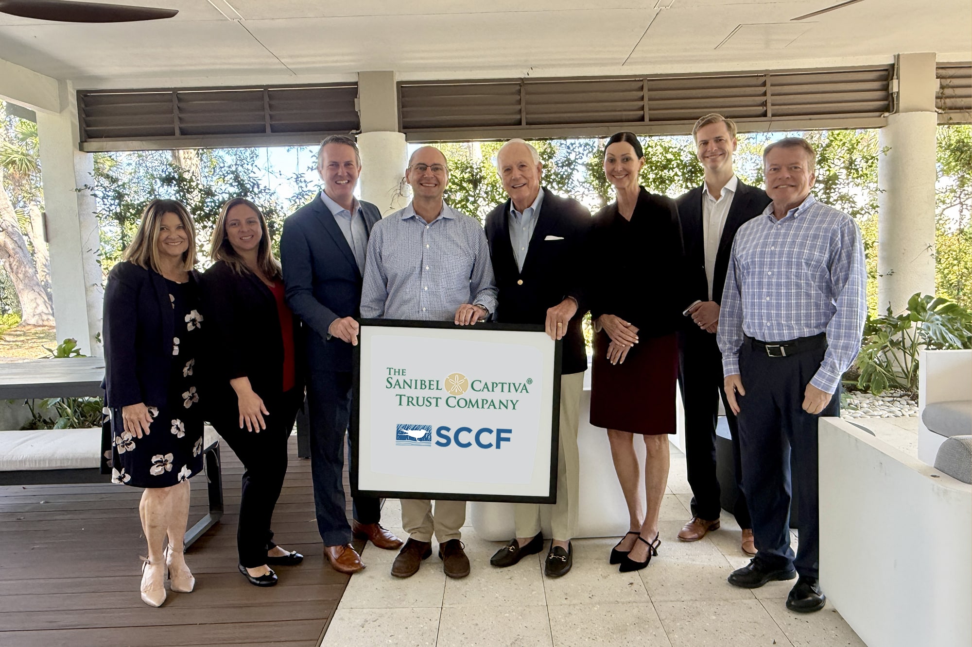 group of people in business clothes holding sign that says 'sancap trust sccf'