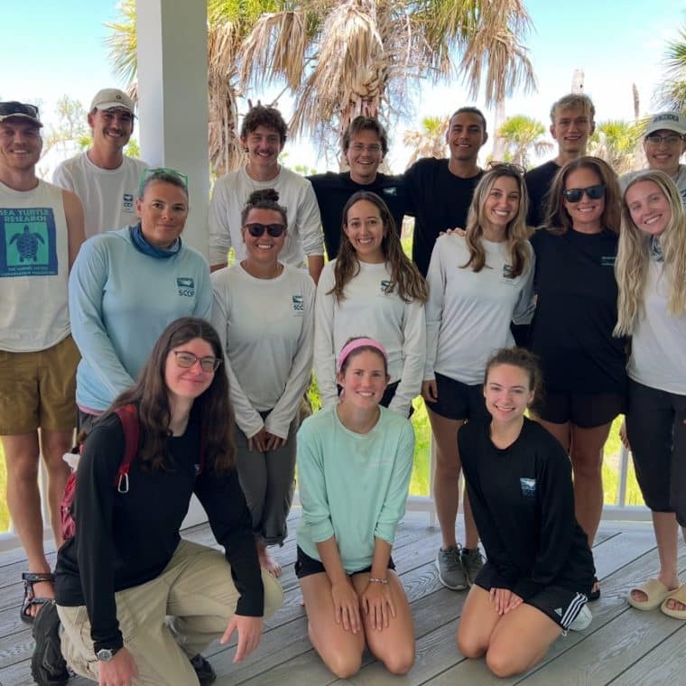 a group of sccf employees smiling outdoors on sanibel