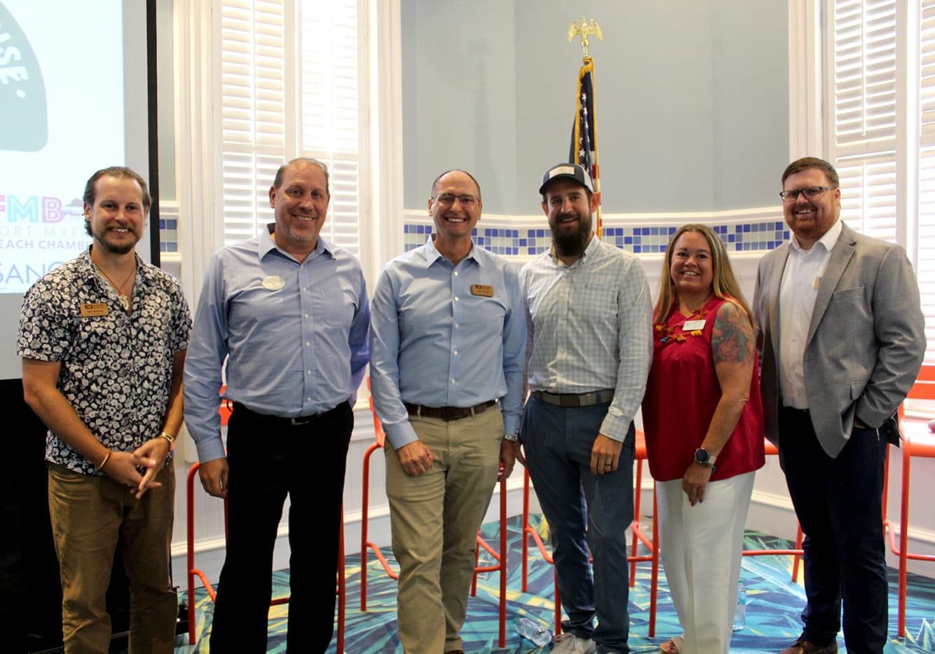 group of six people standing and smiling indoors