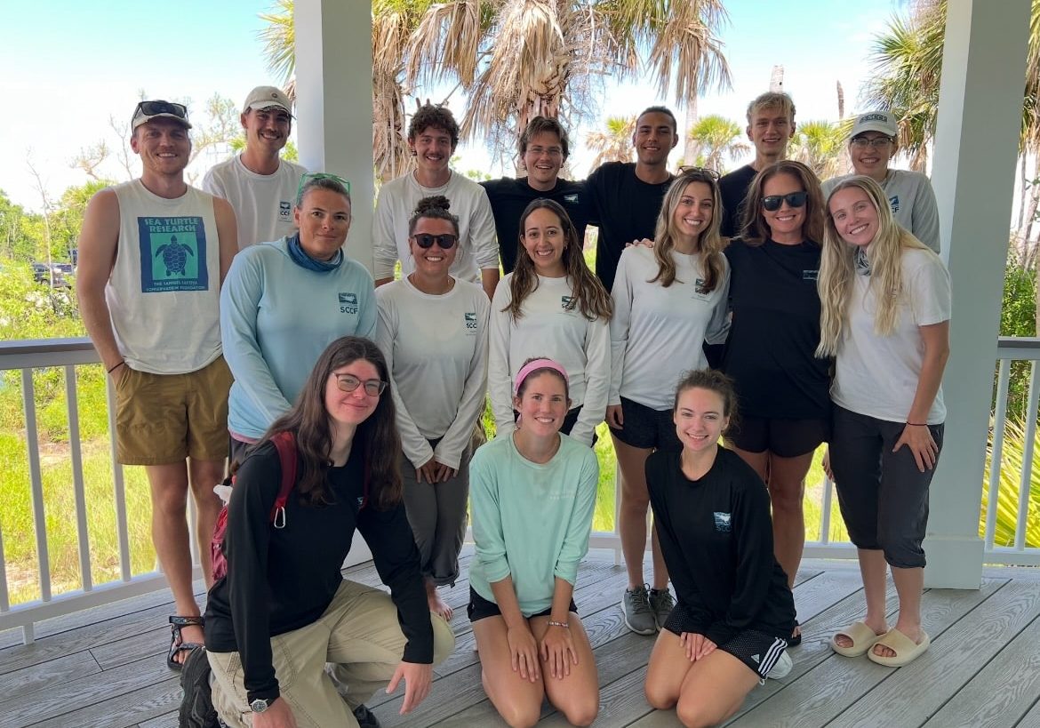 a group of sccf employees smiling outdoors on sanibel