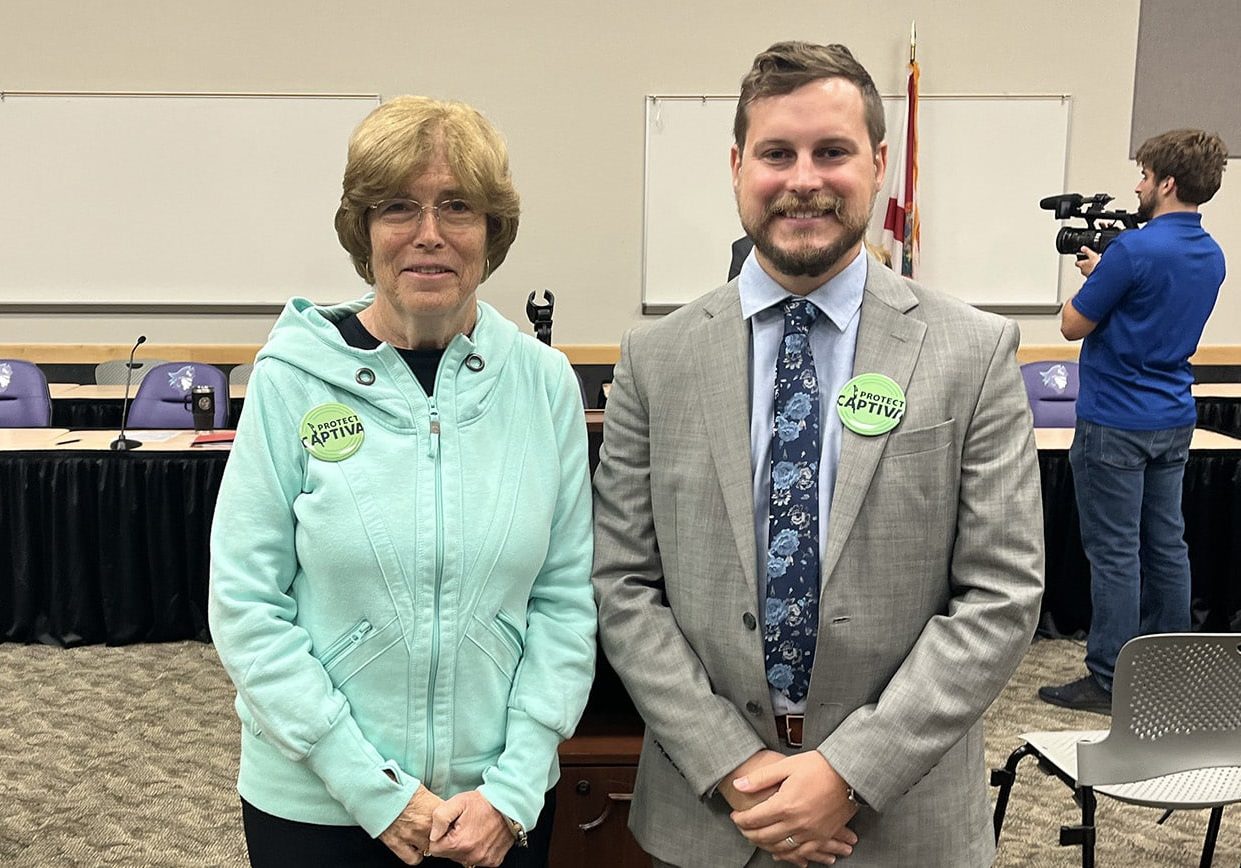 two people in a room smiling with buttons that read 'protect captiva'